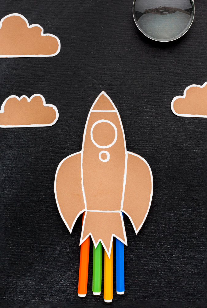 Ausgeschnittene Papierrakete startet ins Weltall aus Karton.