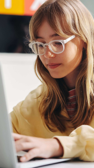 Mädchen mit Brille am Computer.