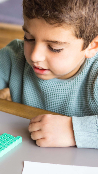 Bub mit 10-er System-Klötzen.