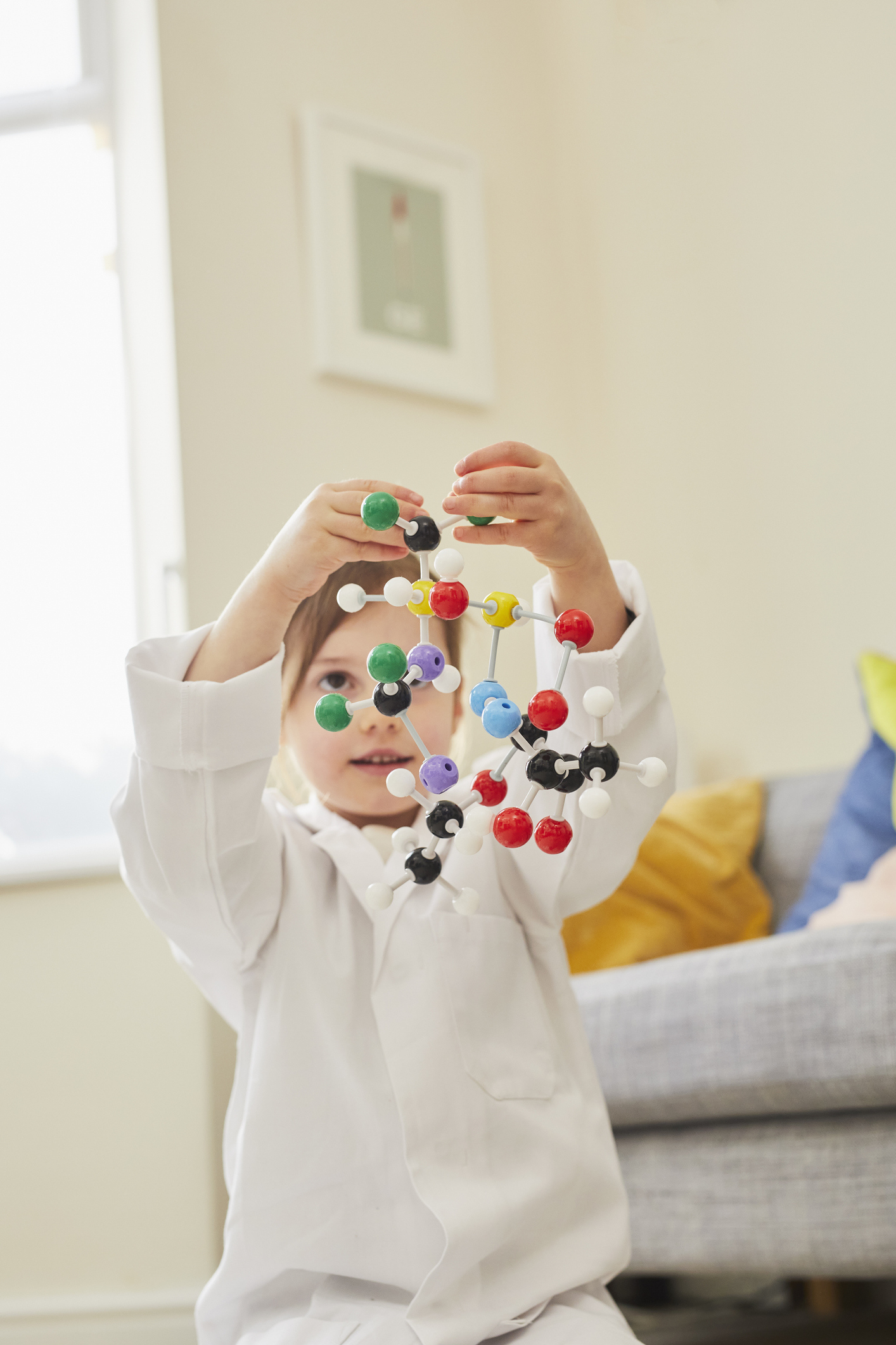 6-jähriges Mädchen, das mit einem Molekül Modell spielt.