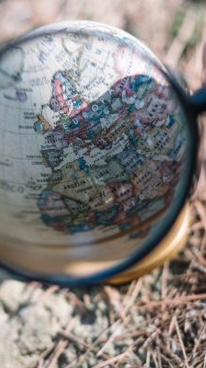 Lupe, die über eine Karte gehalten wird, Fokus auf Europa