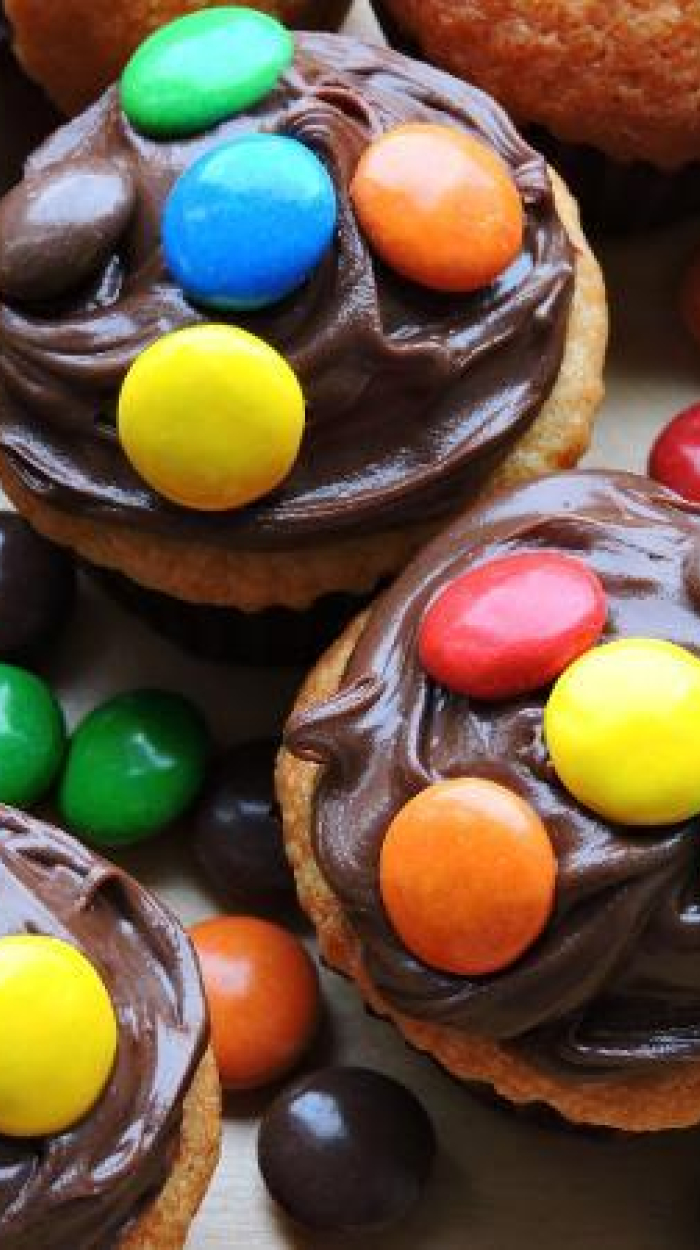 Muffins mit Schokoglasur, dekoriert mit Smarties