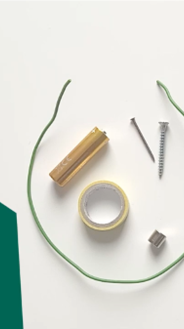 Materialien für ein DIY-Projekt sind zu sehen: eine Batterie, Kabeldrähte, Schrauben, Isolierband und ein Magnet.