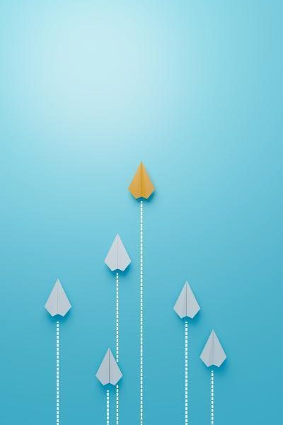 Kleine Papierflieger scheinen auf blauem Hintergrund in verschiedenen Geschwindigkeiten zu fliegen – wobei ein einzelner gelber schneller als alle anderen ist.